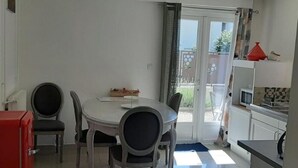 A compact kitchen with a dining area, a small refrigerator, and a microwave.