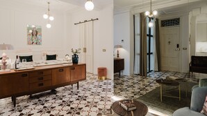 Uma casa de banho moderna com um espelho grande, uma toucador de madeira e um chão estampado.