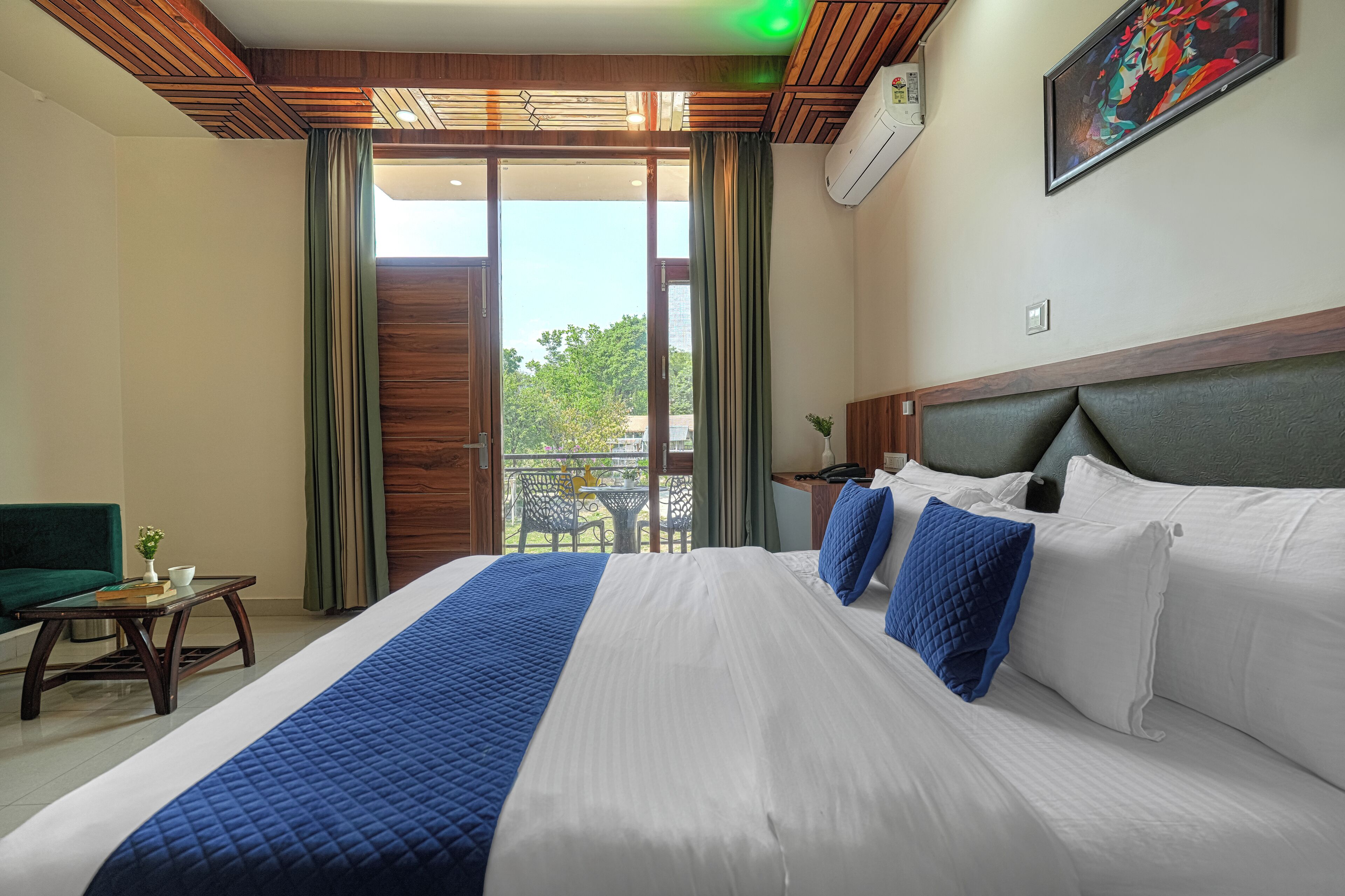 Habitación de hotel con una cama grande, un escritorio, una silla y un balcón con vistas.
