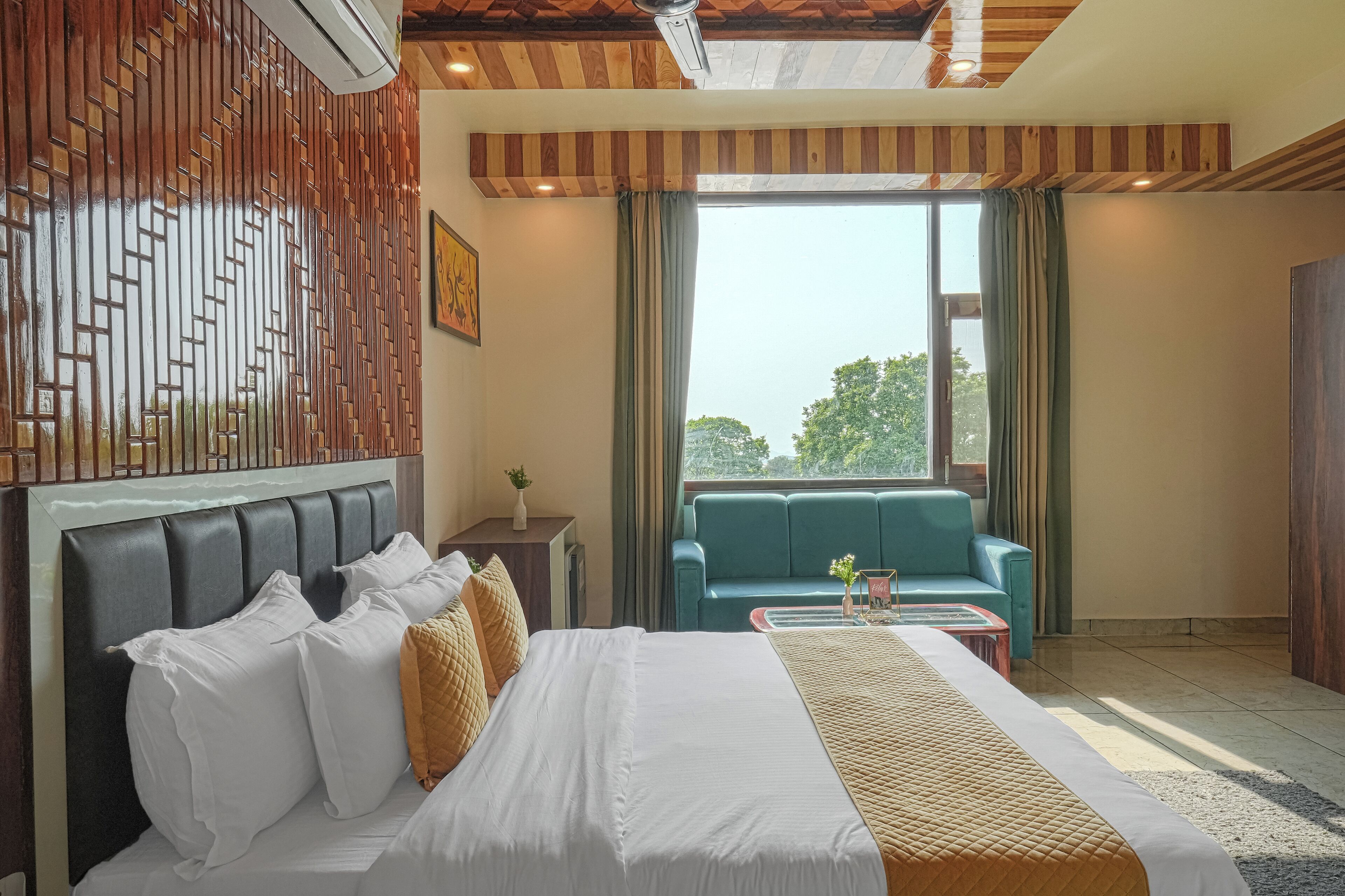A hotel room with a bed, a sofa, a coffee table, and a window with curtains.