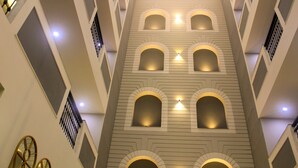 A multi-level interior with arched windows and a central light fixture. - Ahuja Residency Mayfield Garden (Gurugram)
