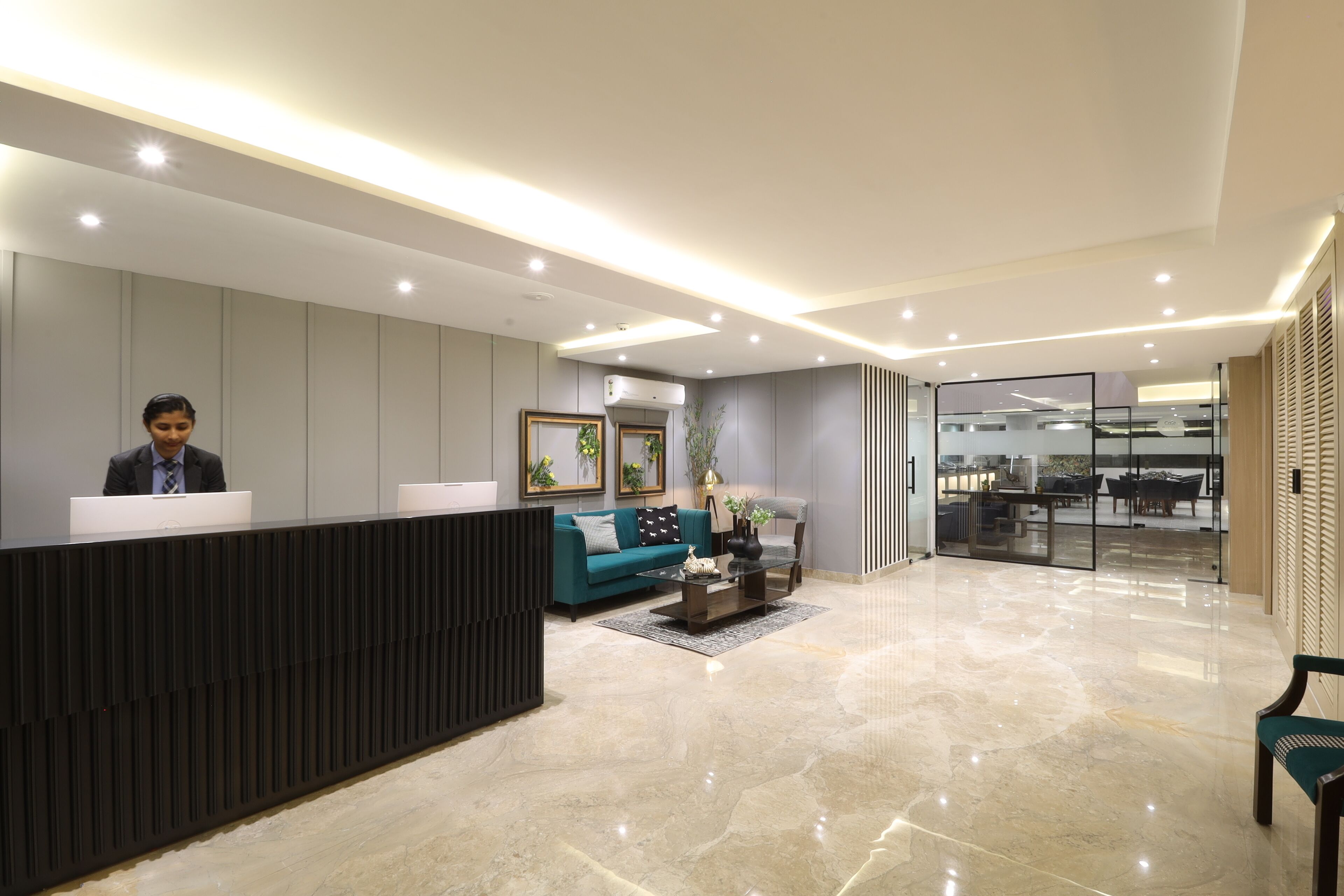 A modern reception area with a reception desk, a sofa, a coffee table, and a chair.