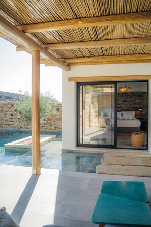 Une villa moderne dotée d’une piscine privée, d’une pergola en bois et d’un mur en pierre servant de décor.