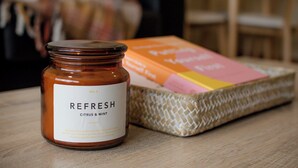 A jar labeled "REFRESH citrus & mint" on a wooden surface.