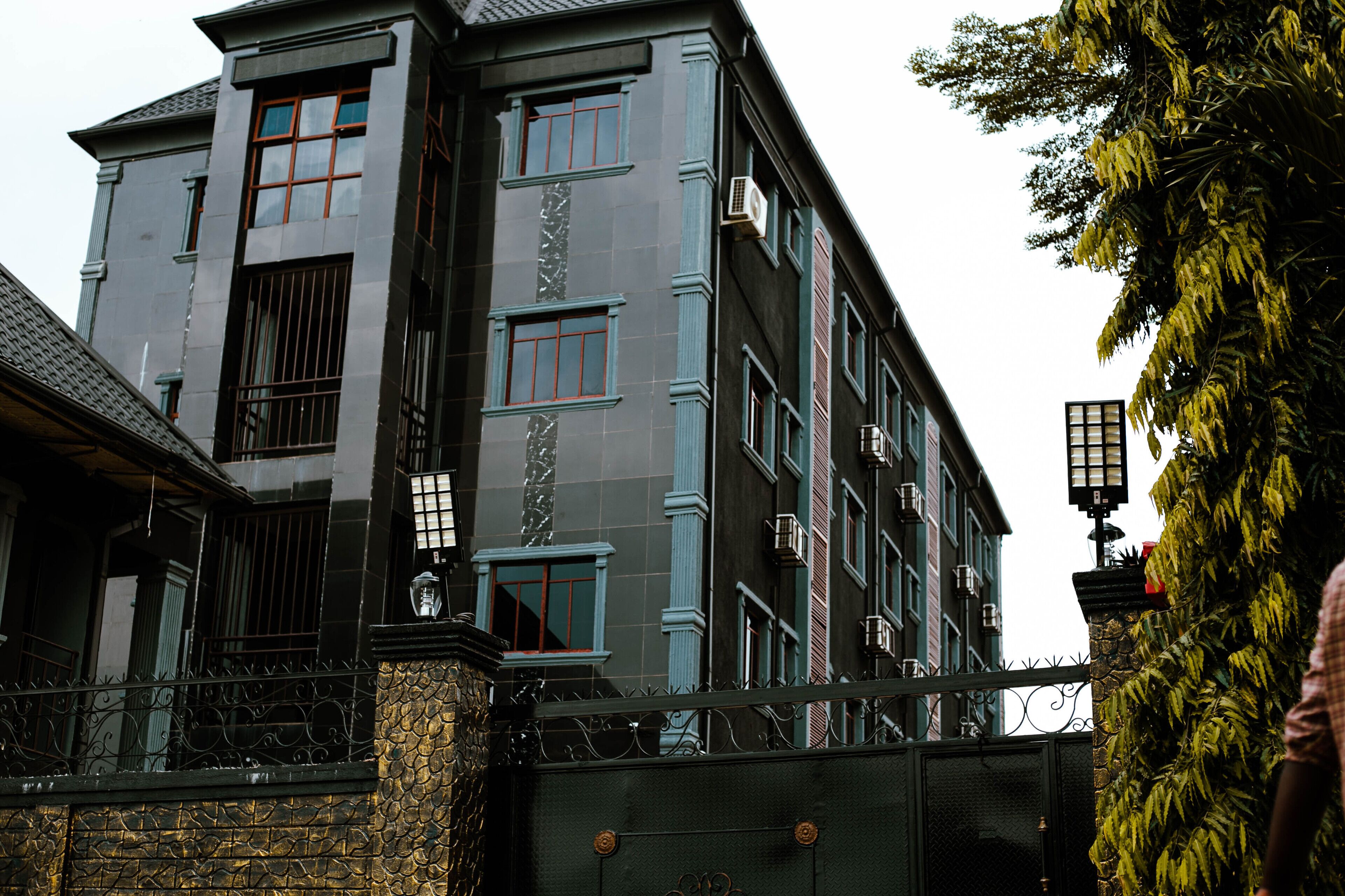 Un edificio de varios pisos con un diseño arquitectónico clásico, que cuenta con amplios ventanales y una entrada porticada.