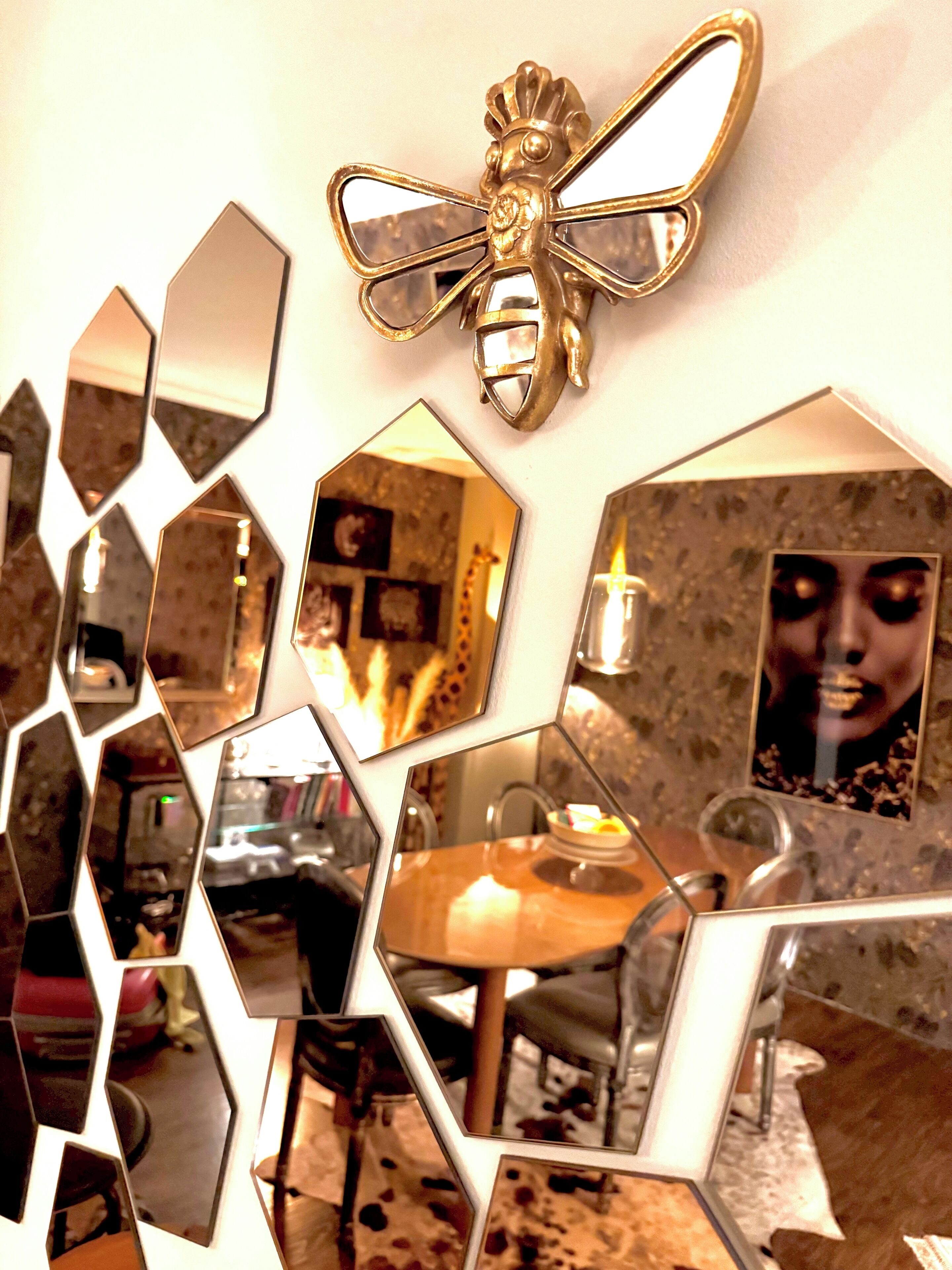 A room with a hexagonal mirror arrangement, a wooden table, and a decorative wall piece.