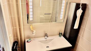 Une salle de bain équipée d’un lavabo, d’un miroir et d’un porte-serviettes.
