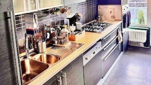 Una cocina moderna con electrodomésticos de acero inoxidable, horno empotrado y un amplio ventanal que proporciona luz natural.