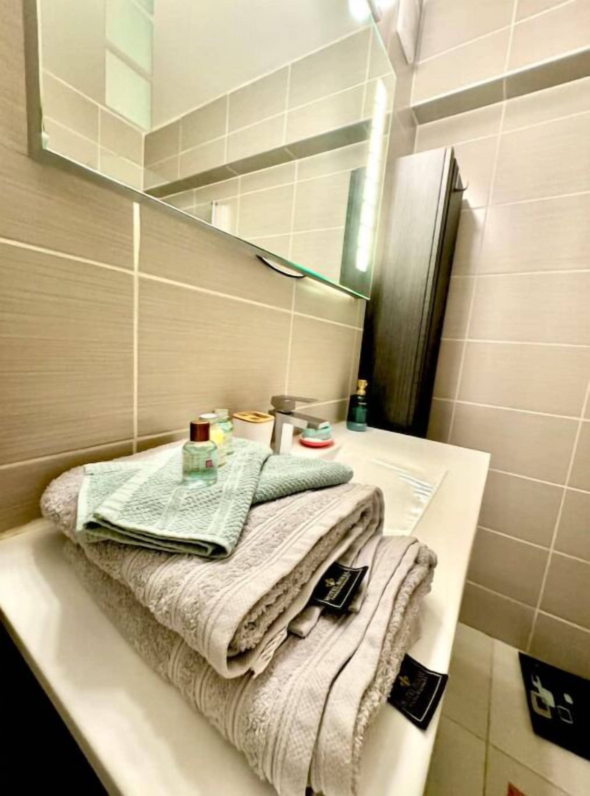 A bathroom with a white sink, a mirror, and a towel rack.