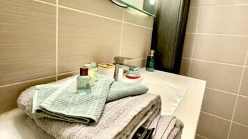 A bathroom with a white sink, a mirror, and a towel rack.