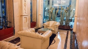 A luxurious lobby with plush seating, a glass coffee table, and a view of the outdoor area through a glass door. - Al Ghubaishi Plaza (Jeddah)