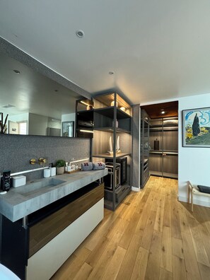 A modern kitchen with a built-in oven, a large island with a sink, and a wooden floor. - Venue C - Luxurious & Spacious ~ Sauna ~ Elevator (Cannes)