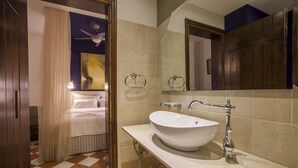 A bathroom with a white sink, a mirror, and a ceiling fan. - Superior double room (Neos Marmaras)