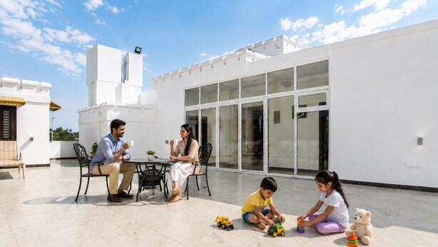 A modern building with a patio area, a dining table, and a white exterior wall. - Hotel Cresent Near Assi Ghat (Varanasi)