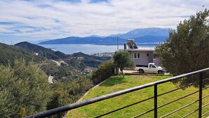 Une vue pittoresque d’une région montagneuse, avec un bâtiment blanc et un camion garé.