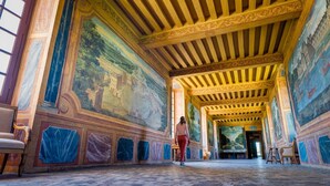 A corridor with a tiled floor and a person walking.