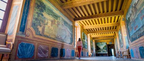 A corridor with a tiled floor and a person walking.