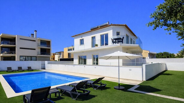 Une maison moderne à deux étages, dotée d’une piscine, d’un espace salon extérieur et d’une pelouse bien entretenue.