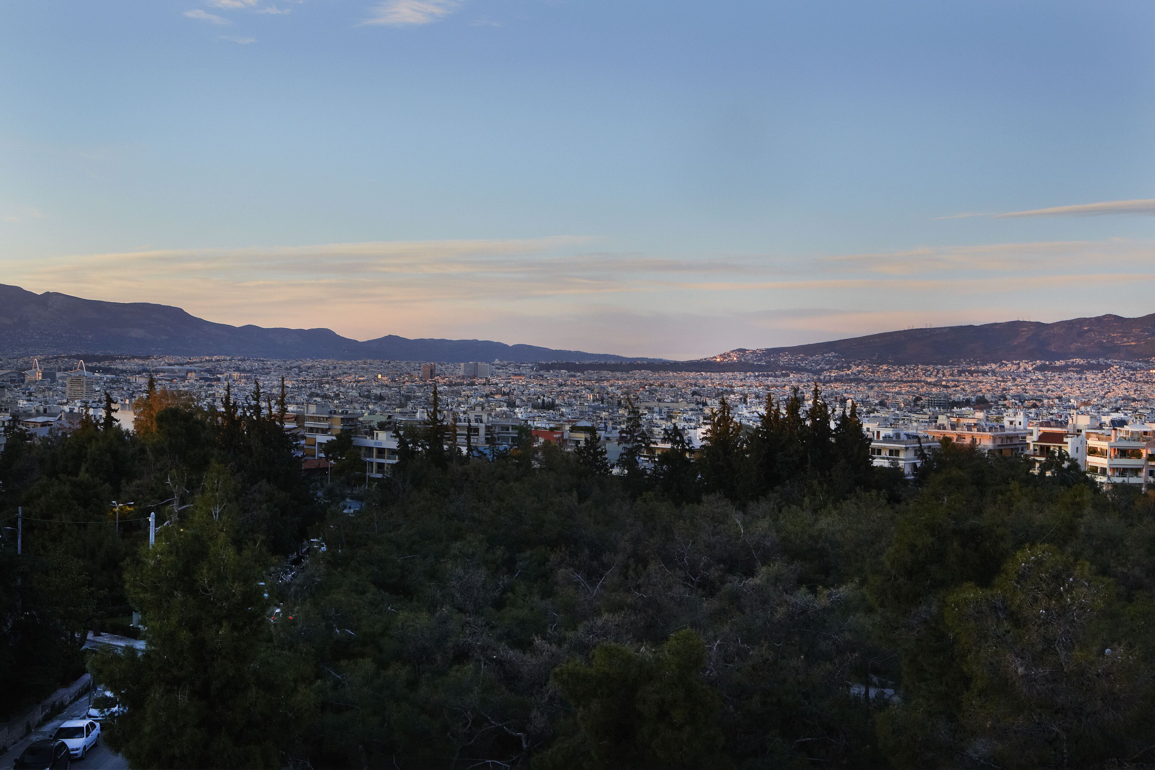 A cityscape with a view of buildings and mountains in the distance.