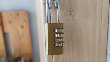 Een messing hangslot met cijfercombinatie op een houten deur.