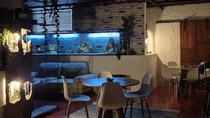 A modern interior with exposed brick walls, a kitchen area with a window, and a seating area with a round table and chairs.