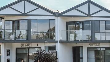A modern two-story building with large windows and a sign reading "Driftwood."