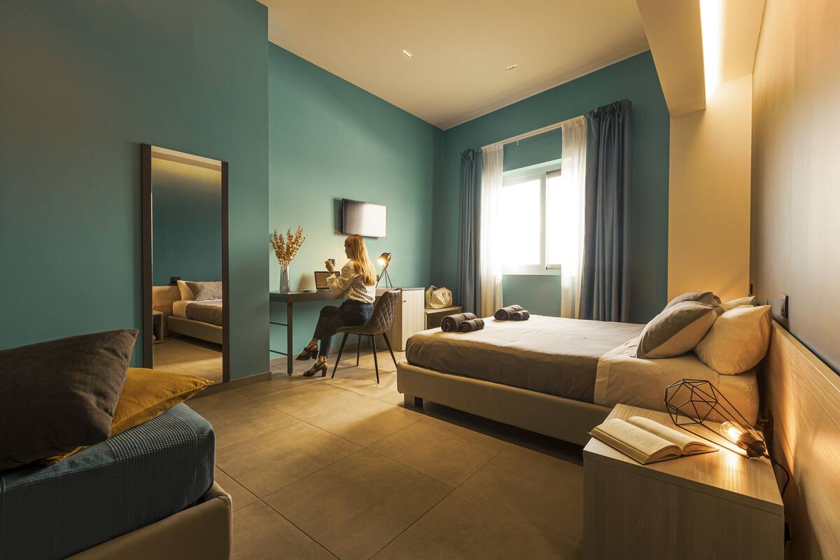 Une chambre d’hôtel moderne, équipée d’un lit, d’un bureau et d’une chaise.