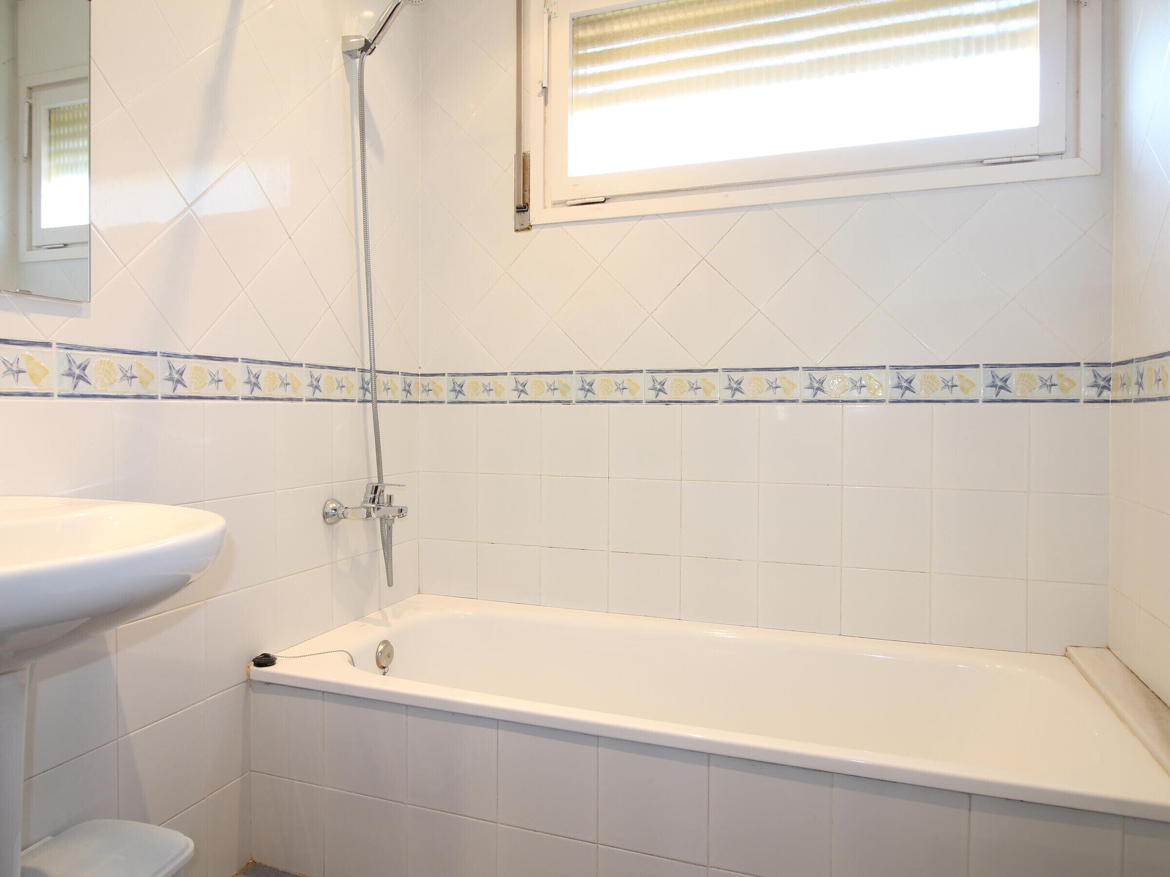 A bathroom with a bathtub, a sink, and a shower.