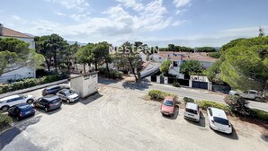 A parking area with several cars, surrounded by buildings and trees. - 1-Bedroom Apartment 100m from Beach - Sleeps 4, Air Conditioning, Nearby Parking (Argelès-sur-Mer)