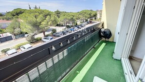 A balcony with a view of parked cars and trees. - 1-Bedroom Apartment 100m from Beach - Sleeps 4, Air Conditioning, Nearby Parking (Argelès-sur-Mer)