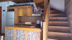 A kitchen with wooden cabinets, a white refrigerator, a coffee maker, and a microwave on the countertop.
