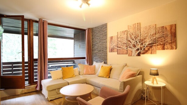 A modern living room with a sectional sofa, a round coffee table, and a small side table. - Duplex in Mont-Dore with parking, near center and slopes (Mont-Dore)