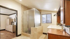 Une salle de bain avec une douche, un lavabo et des placards.