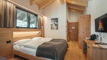 Une pièce aux murs en bois, avec un lit, un bureau et une fenêtre ornée de rideaux.