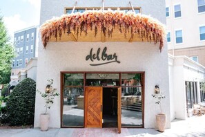 A building with a wooden door and the word "delbar" on the facade. - Birdhaus (Atlanta)