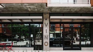 A building with large glass windows and a sign reading "VINO".
