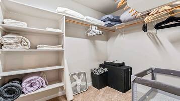 Een netjes ingerichte kast met planken, een hanggedeelte en een kleine ventilator.
