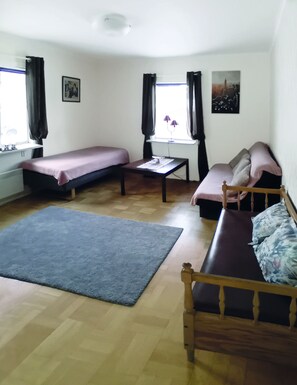 Cozy retreat with a single bed, wooden bench, and a small table with a lamp.