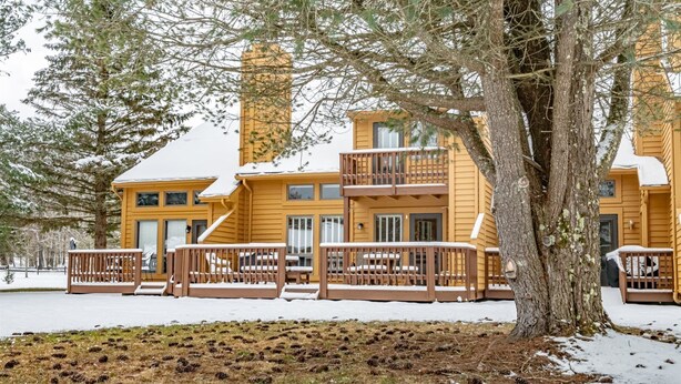 A multi-story wooden building with balconies and a snow-covered ground.