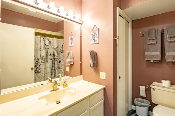 A bathroom with a vanity, sink, mirror, and towel rack.