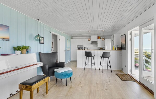 A modern kitchen with white cabinets, a central island, and bar stools.