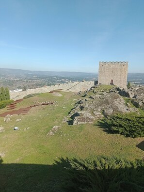 A stone tower on a hill with a view of a valley below. - Cottage Aldeia Da Serra - Historic Areas of Portugal (Celorico da Beira)