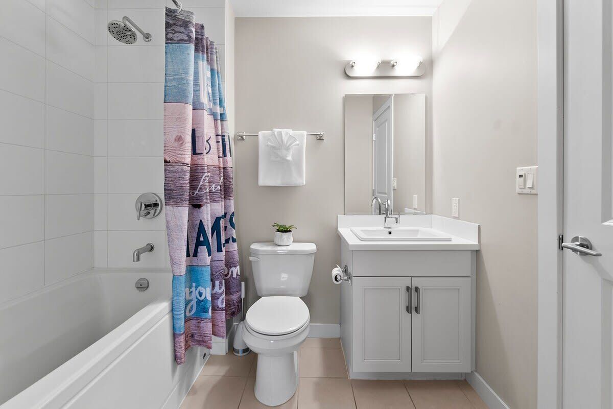 Ein Badezimmer mit Badewanne, Toilette, Waschbecken und Spiegel.
