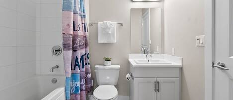Ein Badezimmer mit Badewanne, Toilette, Waschbecken und Spiegel.