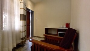 A hallway with a wooden bench and a door leading to another room. - ZIMPARKS BOOKINGS (Hammanskraal)