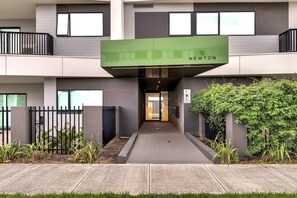 A modern building with a green awning labeled "NEWTON" at the entrance.