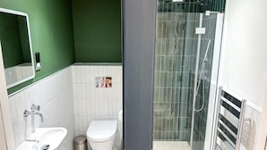 Un baño con inodoro, lavabo y zona de ducha.