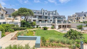 Un complejo residencial con varias casas de dos pisos, un patio central y una piscina.