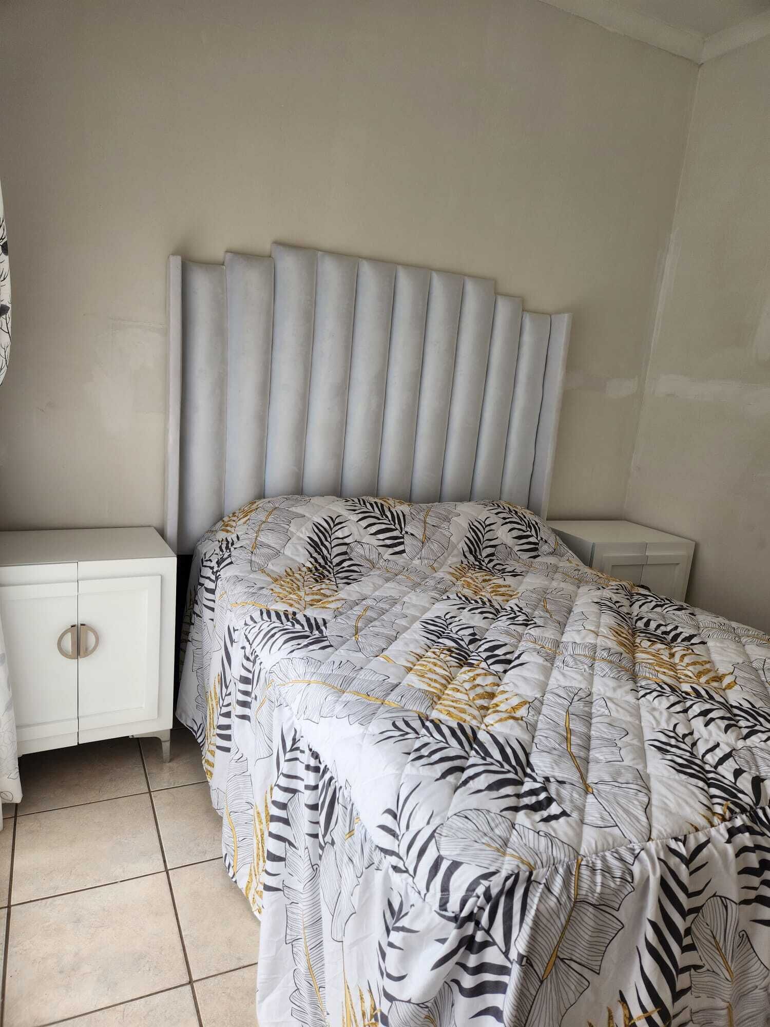 A bedroom with a bed, a nightstand, and a cabinet.