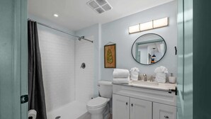 A modern bathroom with a shower, toilet, and vanity. - Historic Elegance Loft in Downtown Conway (Conway)